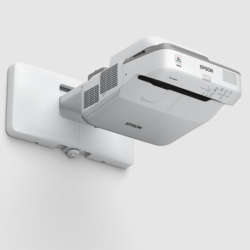Biały projektor ultrakrótkoogniskowy Epson EB-680Wi zamontowany na ścianie.