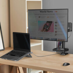 Laptop podłączony do zewnętrznego monitora na biurku z akcesoriami.
