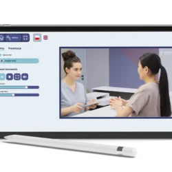 Interfejs aplikacji edukacyjnej na tablecie z odtwarzanym filmem przedstawiającym konsultację pacjentki z pracownikiem medycznym.
