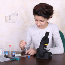 bresser-microscope-national-geographic-40-640x-10 Dziewczyna przygotowuje próbki na szkiełku mikroskopowym przy użyciu pipety i akcesoriów laboratoryjnych.