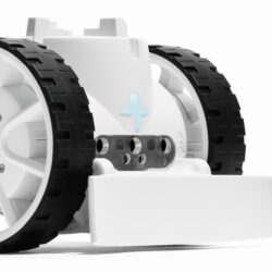 Biały robot edukacyjny z lemieszem i mała piłka nożna na białym tle.