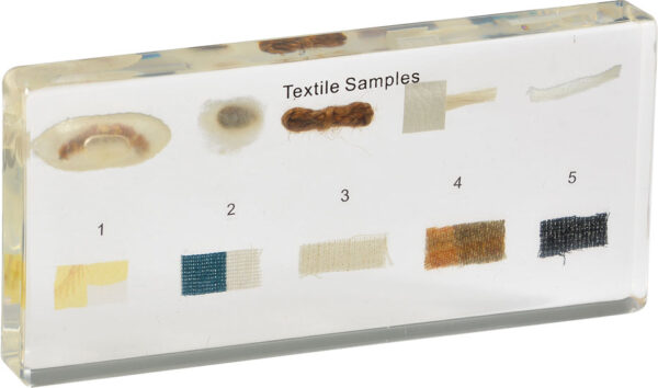 Próbki tekstyliów zatopione w żywicy z ponumerowanymi fragmentami tkanin i napisami Textile Samples.