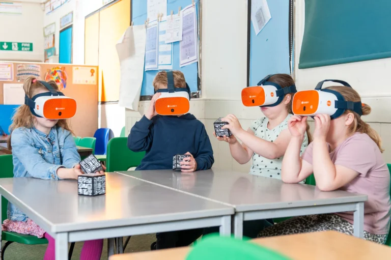 Dzieci w goglach VR ClassVR korzystają z interaktywnych kostek w klasie szkolnej.