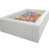 Suchy basen z miękkimi, białymi ściankami wypełniony kolorowymi piłeczkami.
